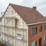 Maison belge en briques avec isolation extérieure en cours d'installation sur la moitié de la façade