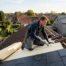 Couvreur installant un isolant thermique sur la toiture d'une maison en Belgique