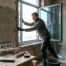 Homme installant une fenêtre à double vitrage dans une maison rénovée