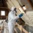 Technicien isolant une toiture avec de la mousse polyuréthane projetée